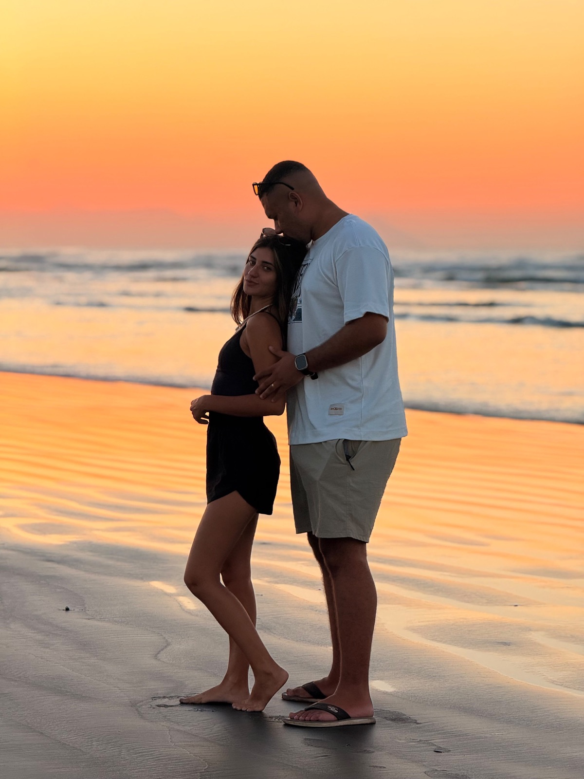 Casal na praia ao pôr do sol, foto feita com celular