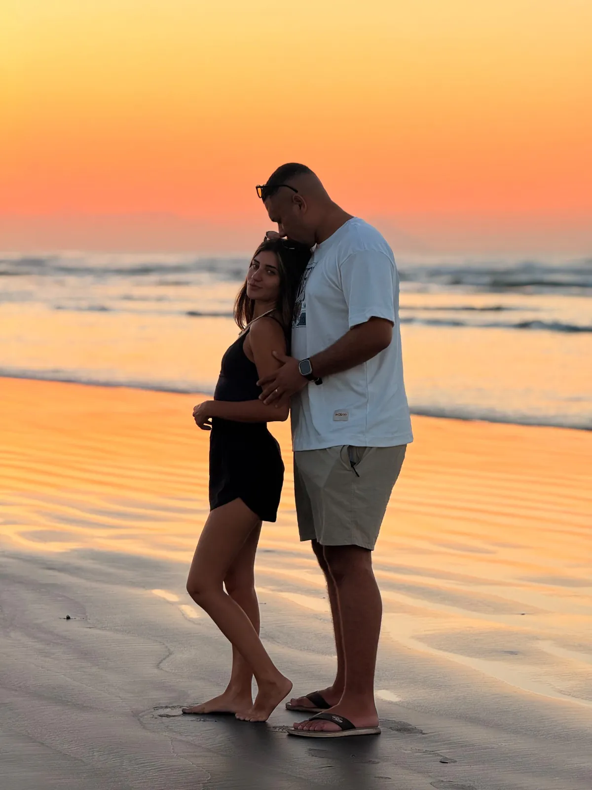 Casal na praia ao pôr do sol, foto feita com celular