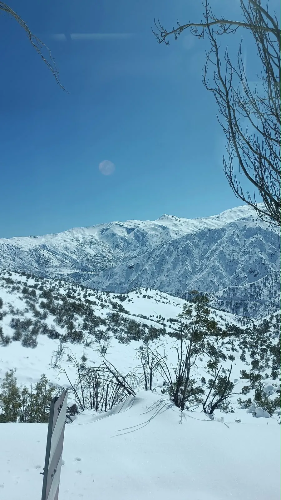 Montanhas cobertas de neve sob céu azul, paisagem feita com celular